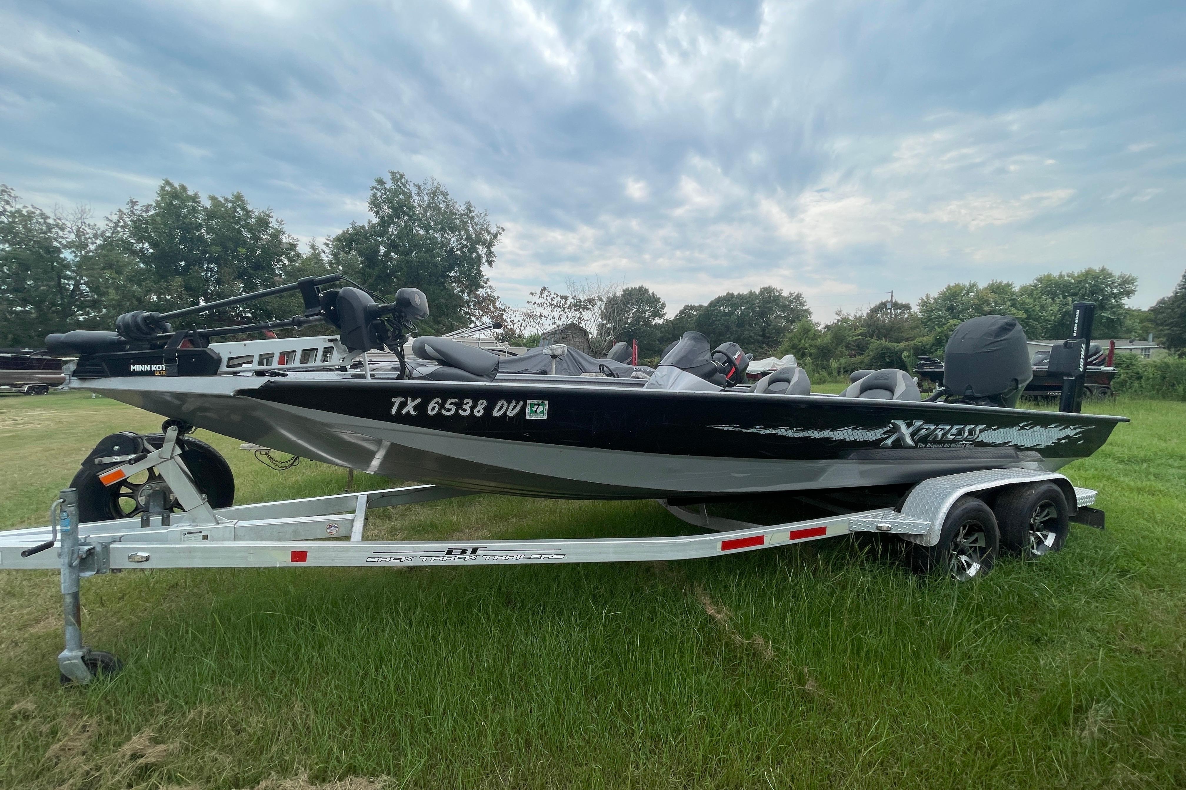 Xpress X21 2017 Xpress X21 boat on trailer, parked on grass under cloudy sky.