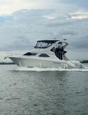 Sea Ray 440 Express Bridge 1996 Sea Ray 440 Express Bridge cruising on open water under cloudy skies.