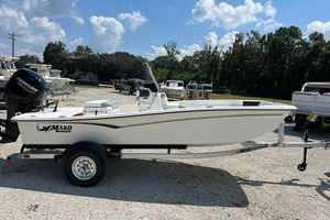 Mako Pro Skiff 15 CC 2026 Mako Pro Skiff 15 CC boat on trailer, parked outdoors under a sunny sky.