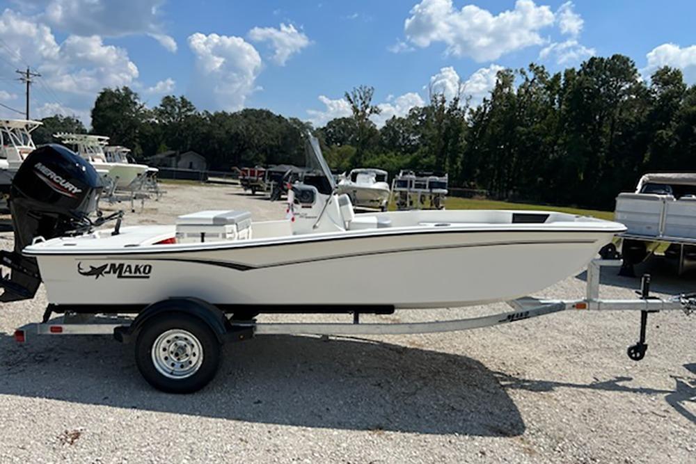Mako Pro Skiff 15 CC 2026 Mako Pro Skiff 15 CC boat on trailer, parked outdoors under a sunny sky.