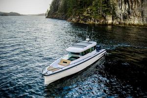 Axopar 37XC CROSS CABIN BRABUS Trim 2025 Axopar 37XC CROSS CABIN BRABUS Trim cruising near rocky shoreline.