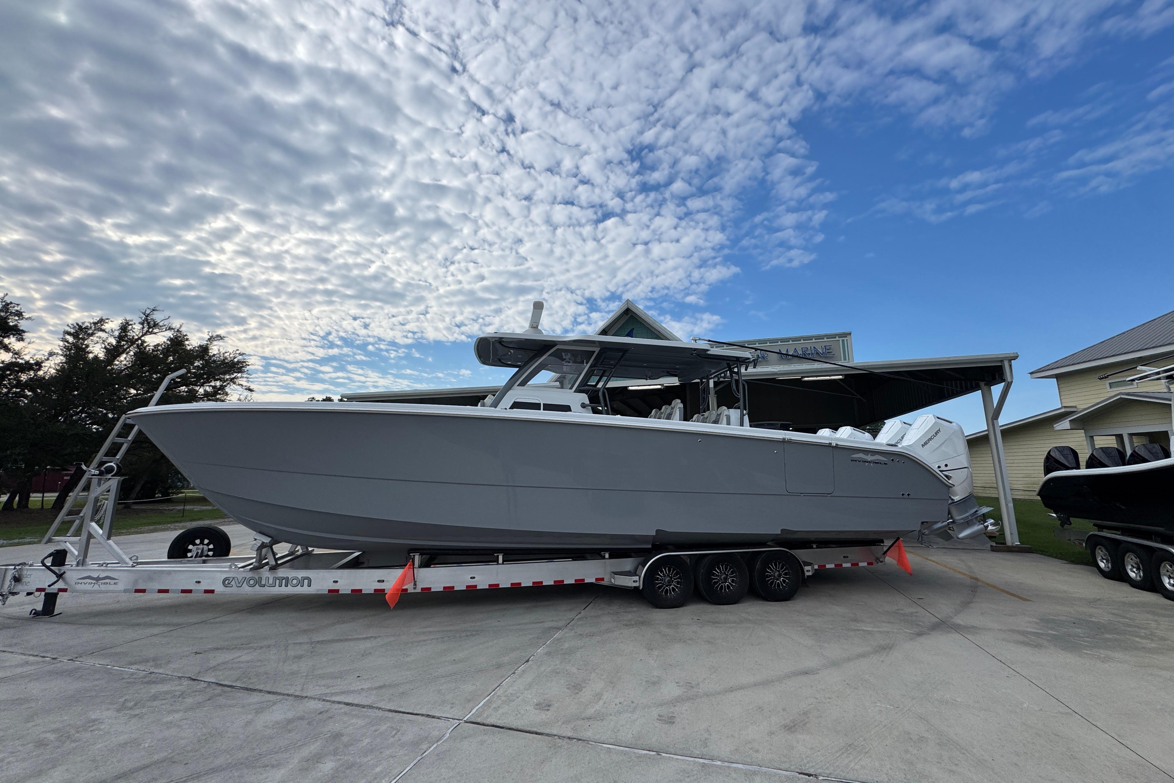 Invincible 40 Catamaran 2026 Invincible 40 Catamaran on trailer under cloudy sky, parked near buildings.