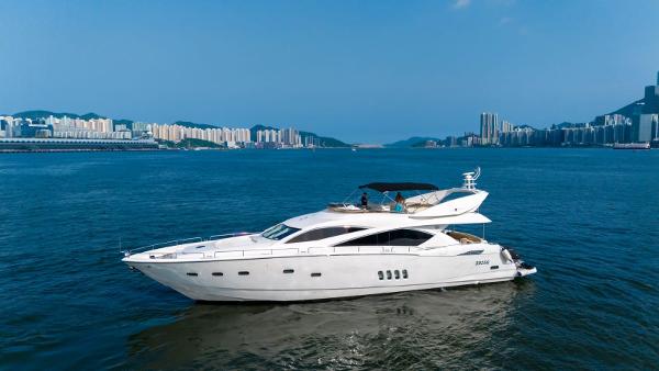 Sunseeker 82 Yacht 2005 Sunseeker 82 Yacht cruising on a calm blue sea with cityscape background.