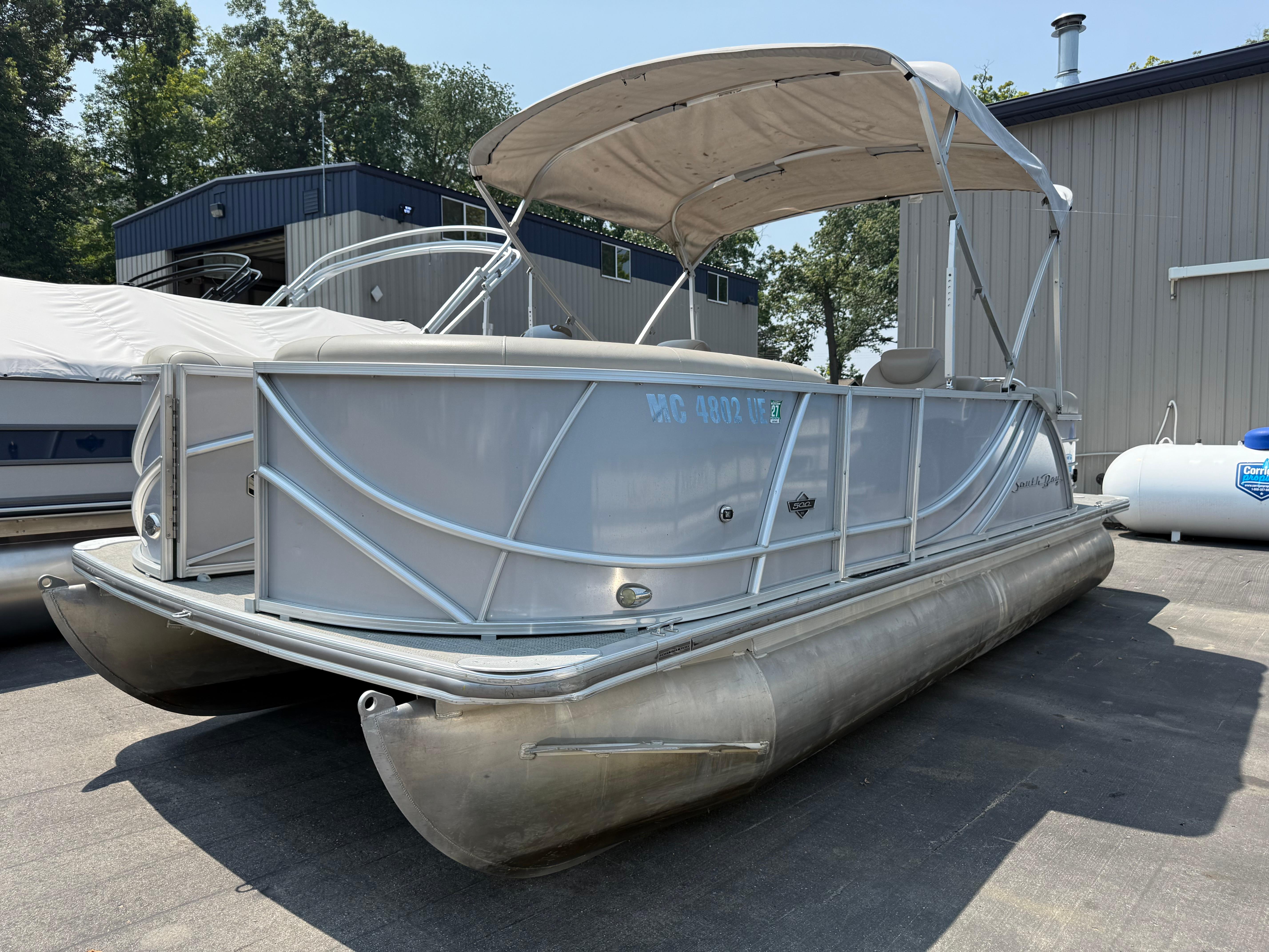 South Bay 521RS 2016 South Bay 521RS pontoon boat with canopy, parked outdoors near a building.