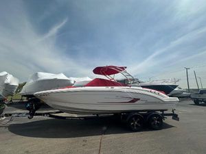 Chaparral 23 SSi 2023 Chaparral 23 SSi boat with red canopy on trailer, parked outdoors.