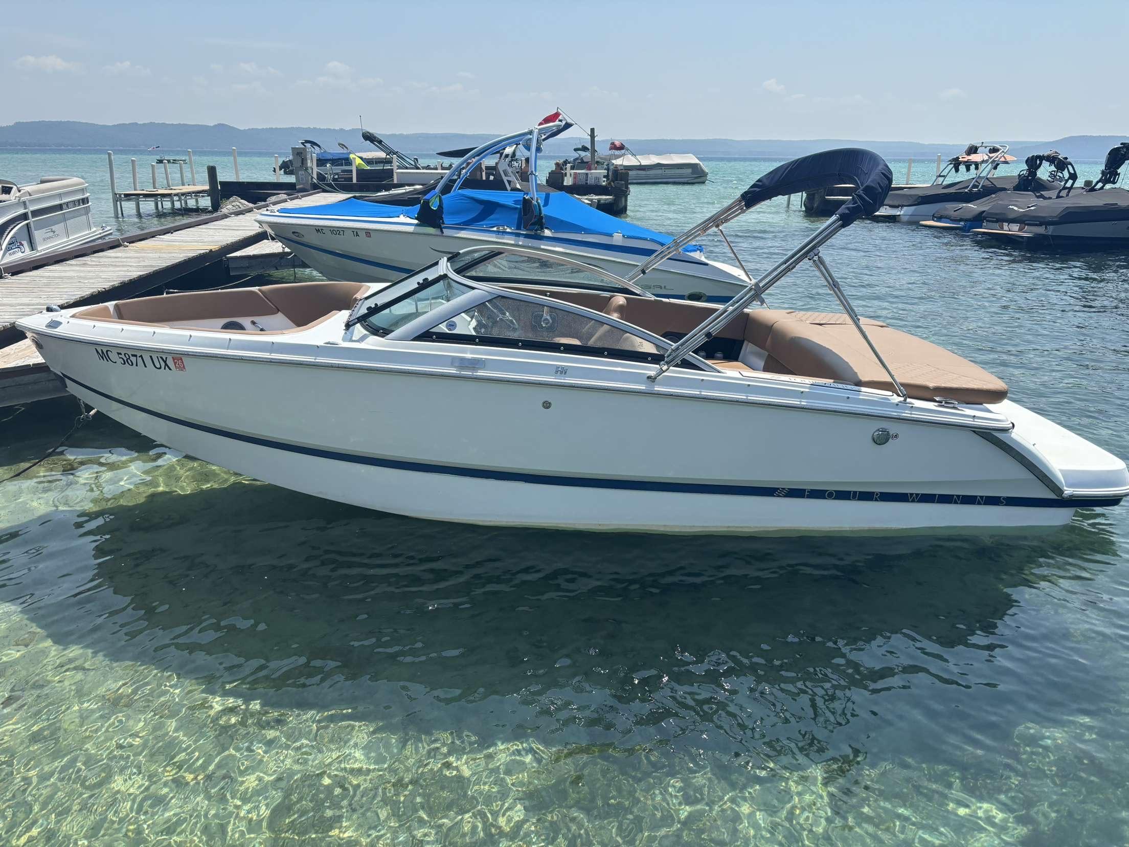 Four Winns H1 2024 Four Winns H1 boat docked on clear water, sunny day.