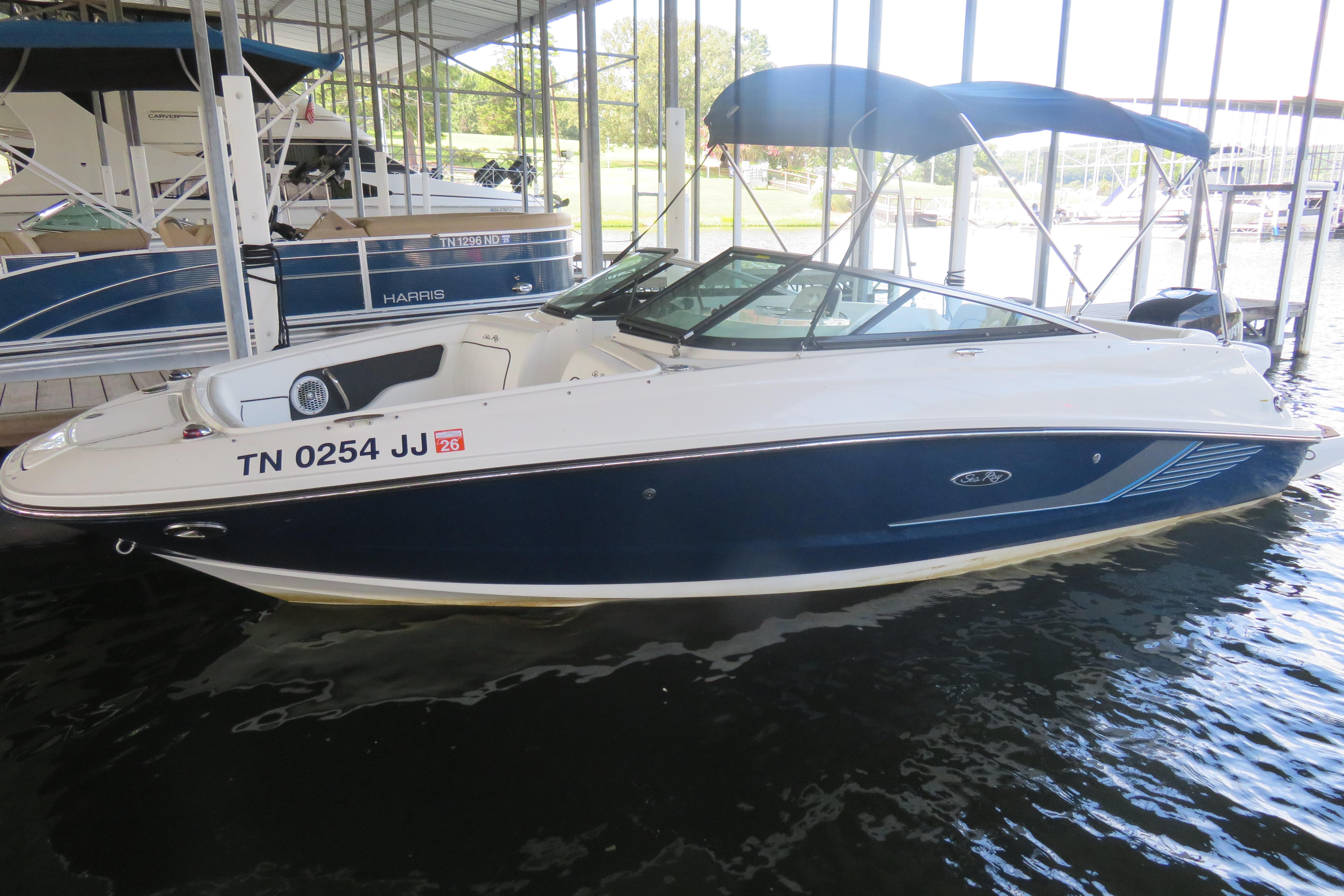 Sea Ray 220 Sundeck Outboard 2014 Sea Ray 220 Sundeck Outboard boat docked in marina with blue canopy.
