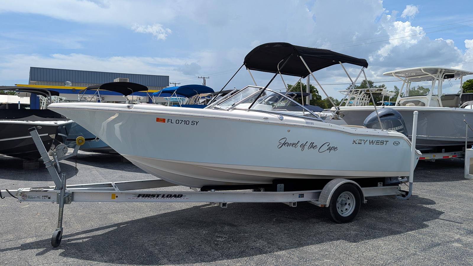 Key West 203 DFS 2021 Key West 203 DFS boat on trailer, labeled "Jewel of the Cape," in a parking lot.