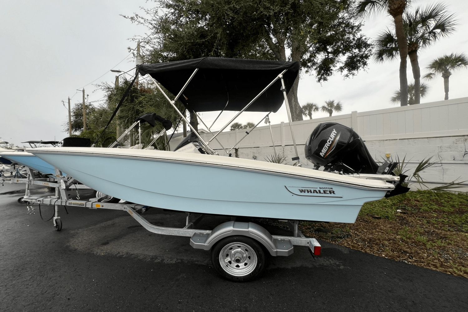 Boston Whaler 130 Super Sport 2025 Boston Whaler 130 Super Sport boat on trailer, featuring Mercury outboard motor.