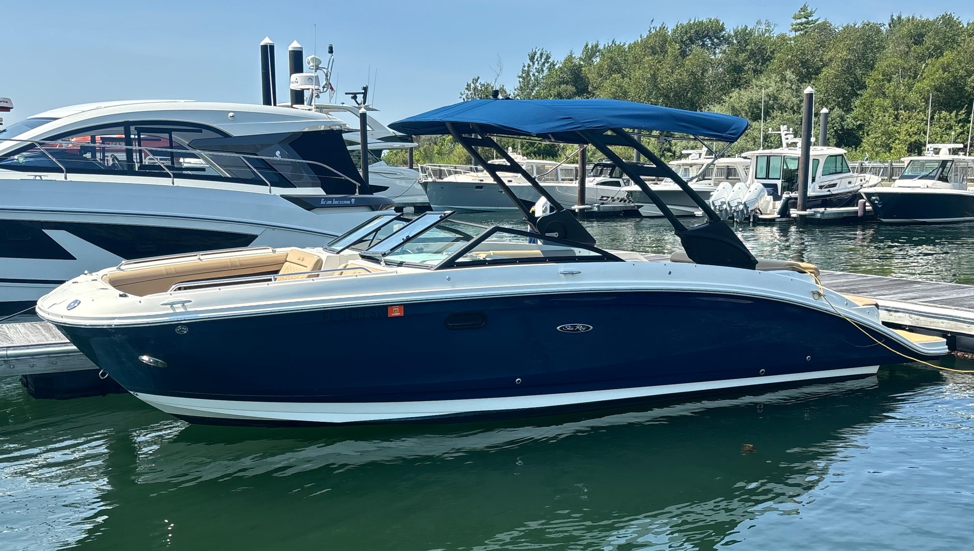 Sea Ray SDX 270 2021 Sea Ray SDX 270 boat docked in a marina, featuring a sleek blue design.