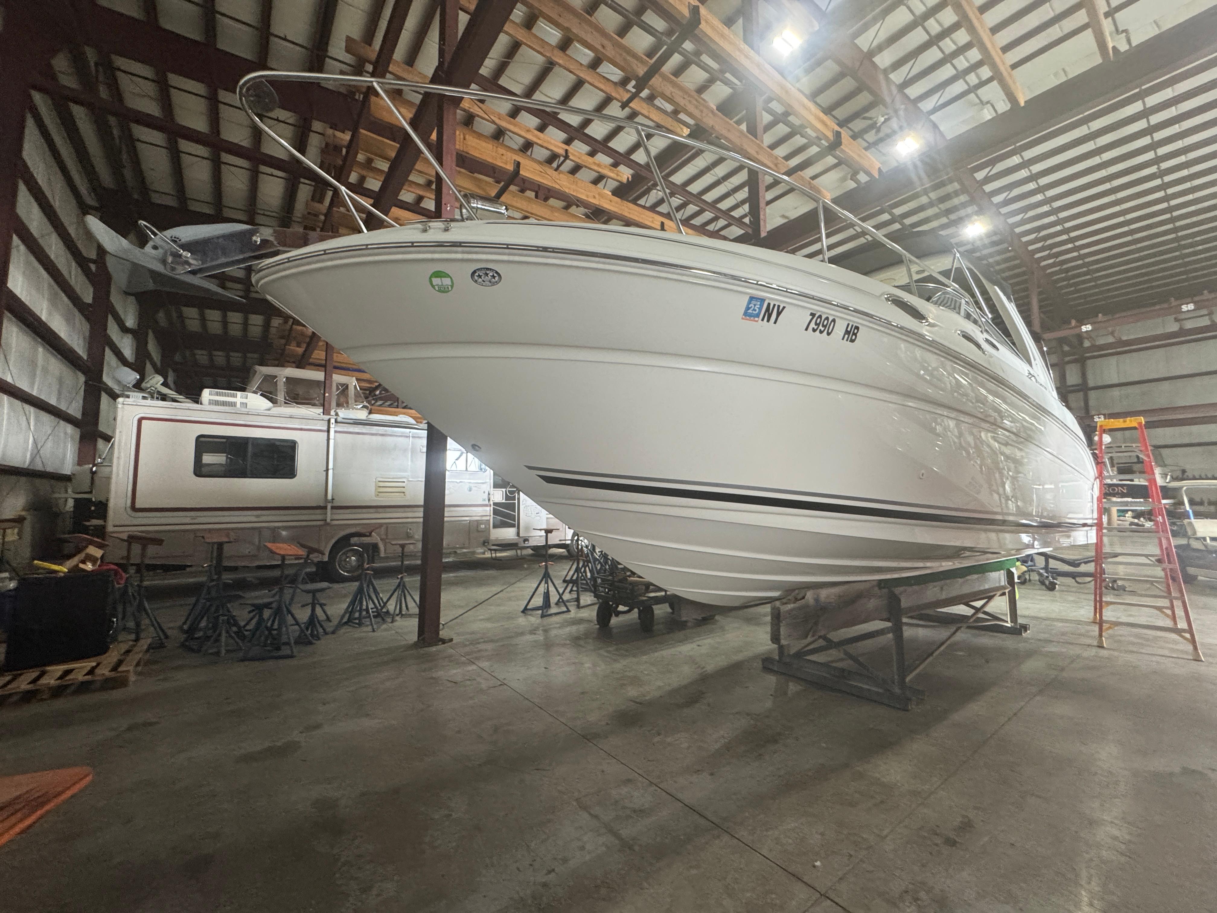 Sea Ray 260 Sundancer 2004 Sea Ray 260 Sundancer boat in storage, elevated on stands in a warehouse.