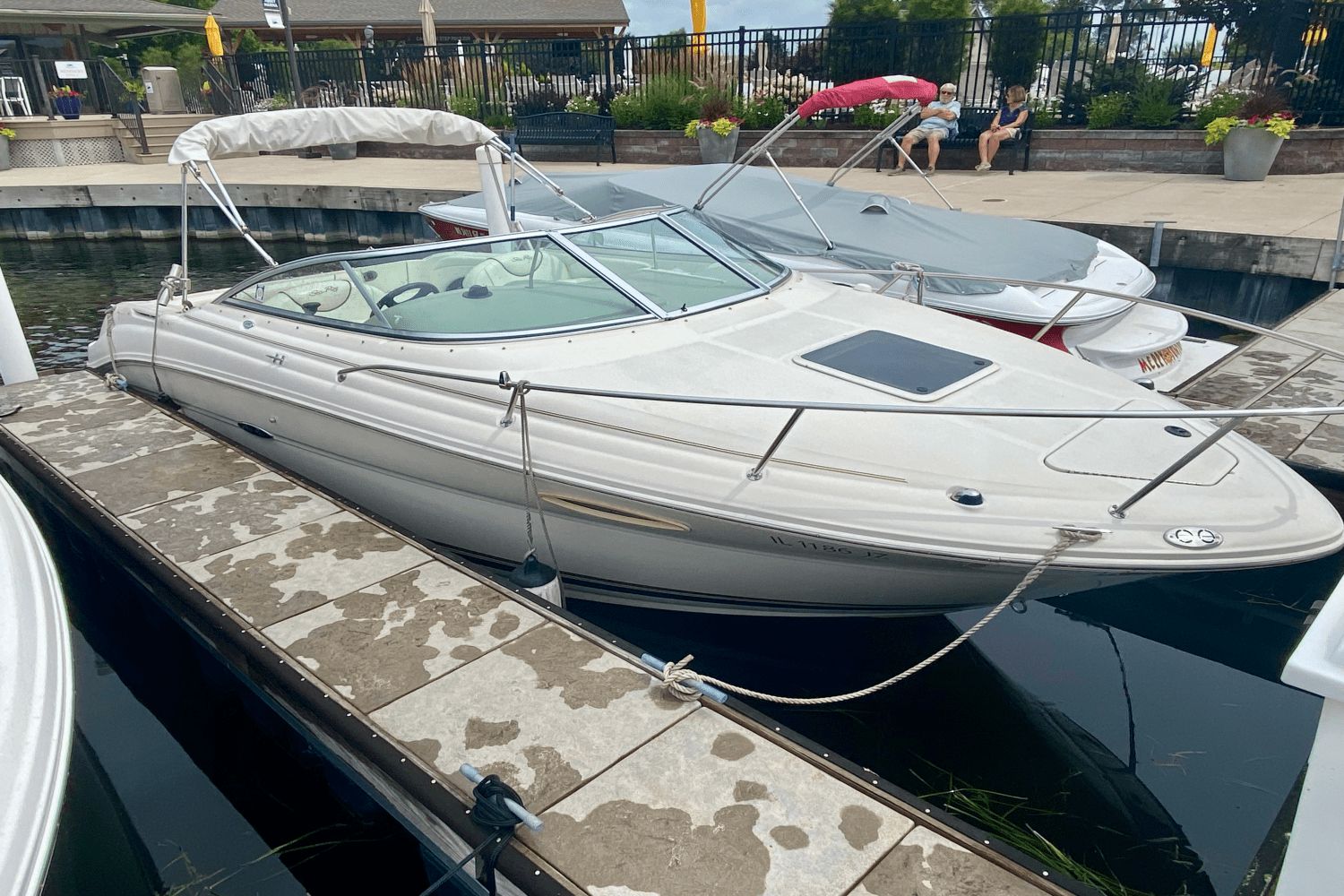 Sea Ray 225 Weekender 2004 Sea Ray 225 Weekender boat docked at marina with canopy and sleek design.