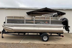 Sun Tracker Party Barge 18 DLX 2024 Sun Tracker Party Barge 18 DLX pontoon boat on trailer, parked outdoors.
