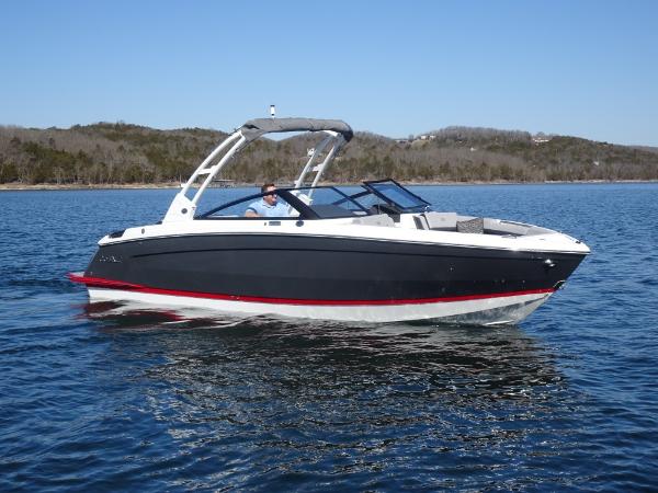 Cobalt R8 2025 Cobalt R8 boat cruising on a serene lake under a clear blue sky.