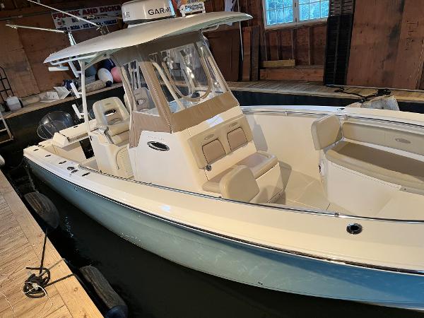 Cobia 296 CC 2016 Cobia 296 CC boat docked indoors with beige seating and Garmin electronics.