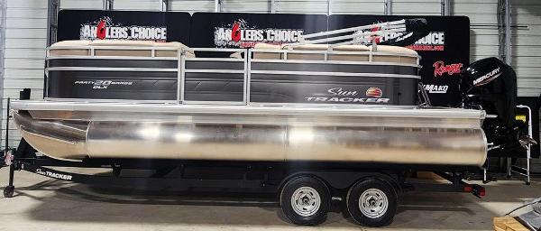 Sun Tracker Party Barge 20 DLX 2025 Sun Tracker PARTY BARGE® 20 DLX pontoon boat on trailer in showroom.
