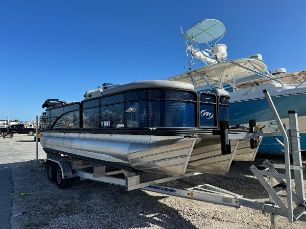 Manitou 23' Oasis RFSHP373 2022 Manitou 23' Oasis RFSHP373 pontoon boat on trailer, parked outdoors.