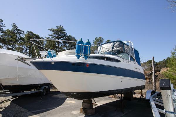 Bayliner 245 Cierra 2007 Bayliner 245 Cierra boat on dry dock, surrounded by trees and clear sky.