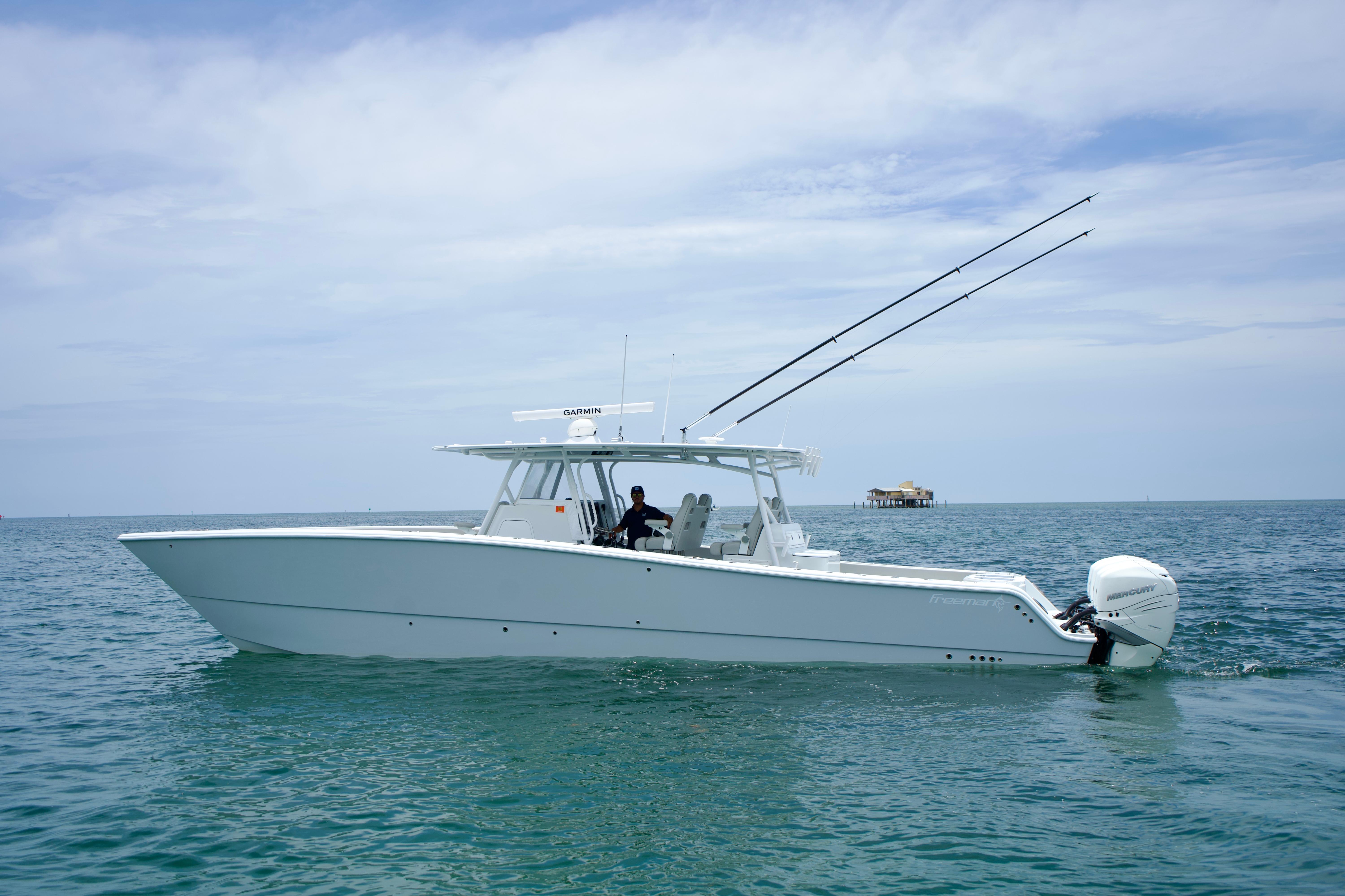Freeman 42 LR 2022 Freeman 42 LR boat on calm ocean waters, equipped with fishing rods and outboard motors.