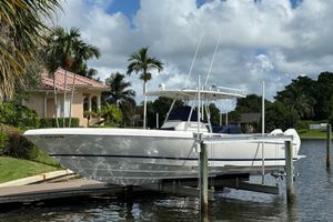 Intrepid 323 OPEN 2009 Intrepid 323 boat docked by a waterfront home with palm trees.