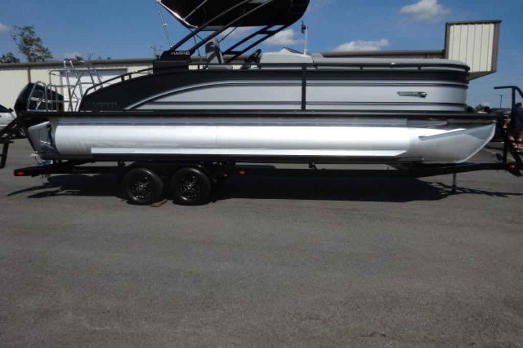 Harris Solstice 250 2026 Harris Solstice 250 pontoon boat on trailer, parked outdoors under clear sky.