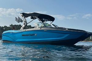 MasterCraft X24 2019 MasterCraft X24 boat on water, blue hull, sleek design, sunny day.