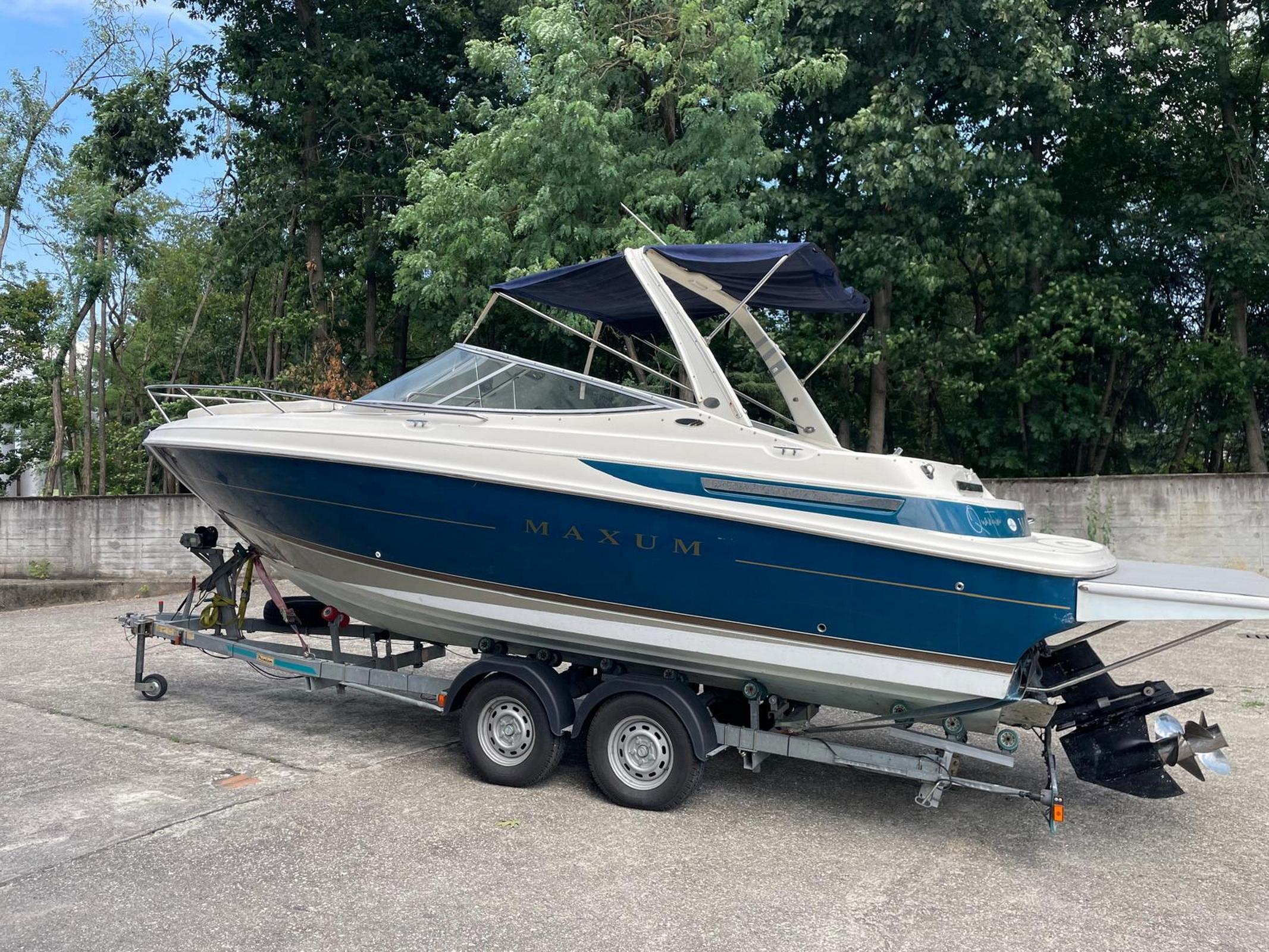 Maxum 2300 SC 1997 Maxum 2300 SC boat on trailer, parked outdoors with trees in background.