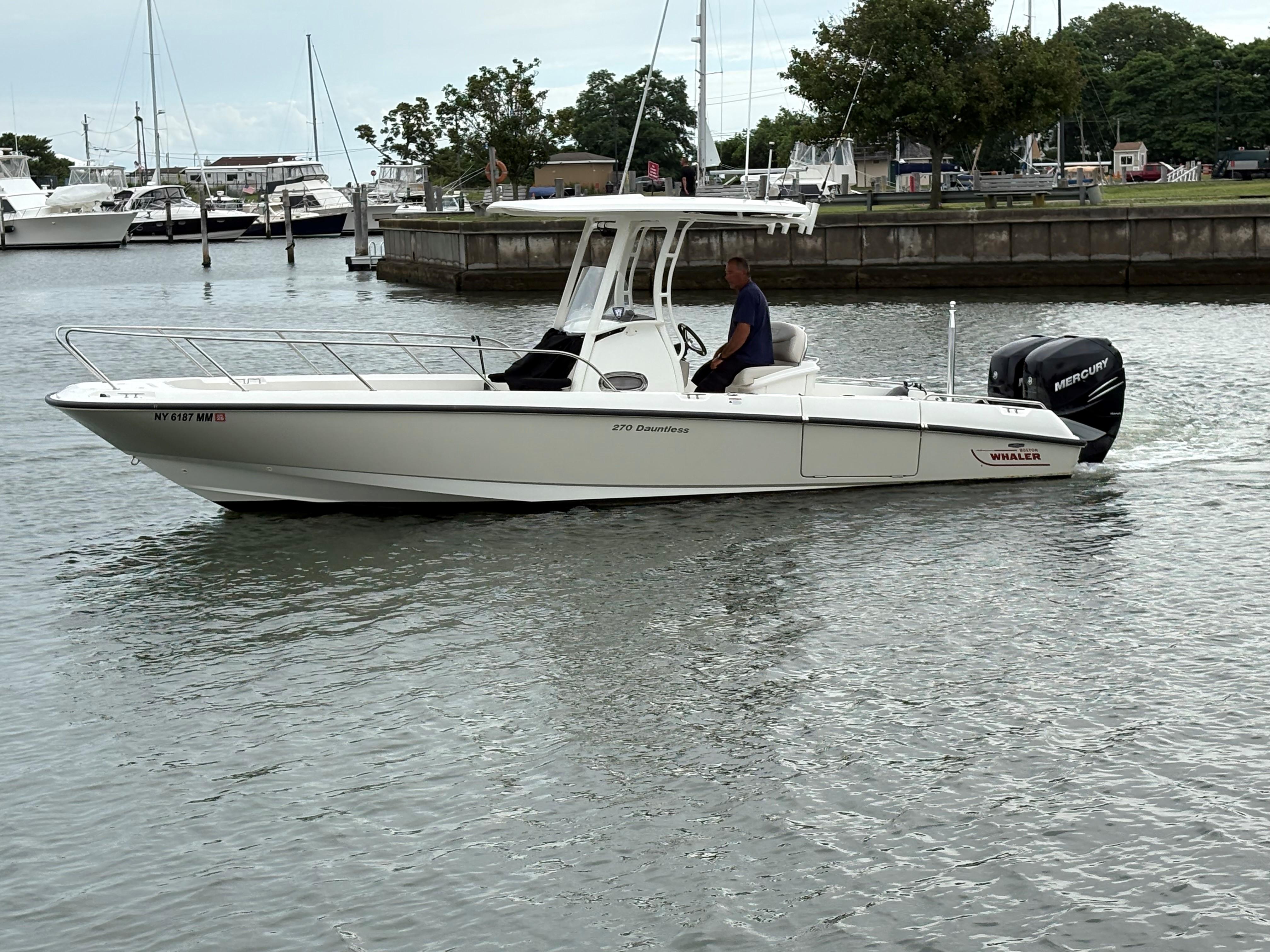 Boston Whaler 270 Dauntless 2017 Boston Whaler 270 Dauntless boat on water, with Mercury engine, docked in marina.