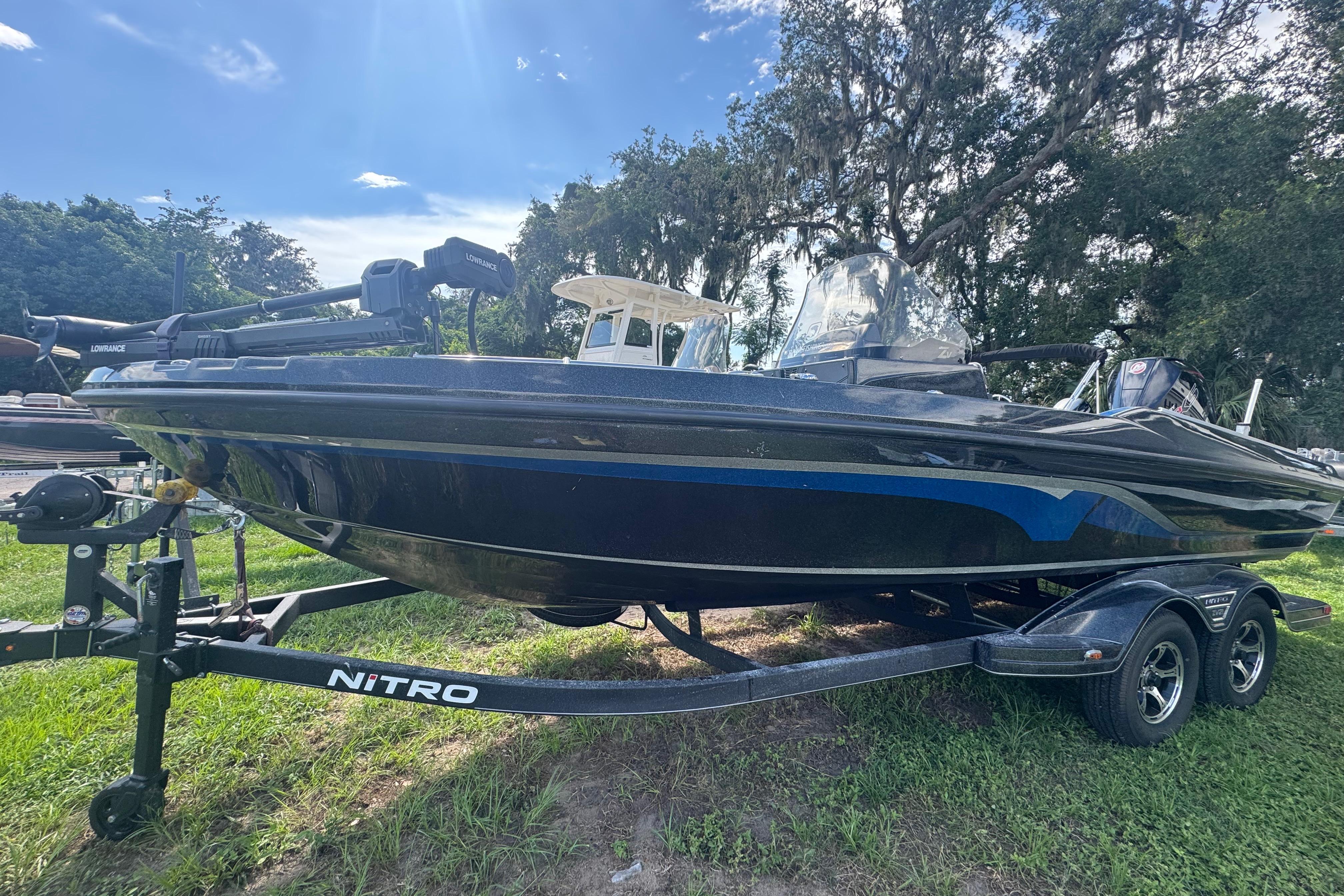 Nitro ZV21 2024 Nitro ZV21 boat on trailer, parked on grass under a clear blue sky.