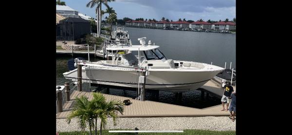 Pursuit S 358 Sport 2023 Pursuit S 358 Sport boat docked by waterfront homes.