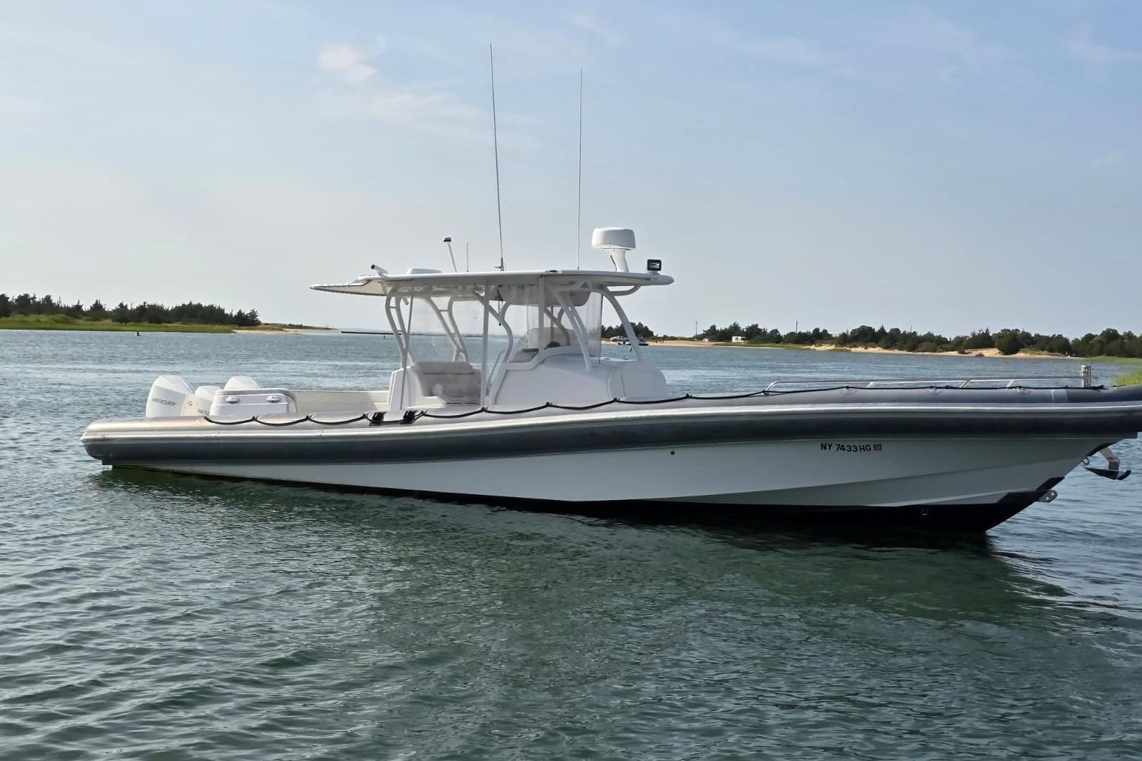 Yellowfin RIB 2015 Yellowfin RIB boat on calm water, clear sky, shoreline in background.