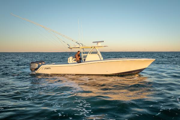 Invincible 36 CC 2020 Invincible 36 CC boat cruising on open water at sunset.
