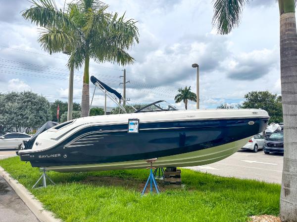Bayliner DX2200 2024 Bayliner DX2200 boat displayed outdoors with palm trees in the background.