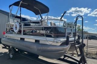 Sun Tracker Bass Buggy 16 DLX ET 2019 Sun Tracker Bass Buggy 16 DLX ET pontoon boat on trailer, sunny day.