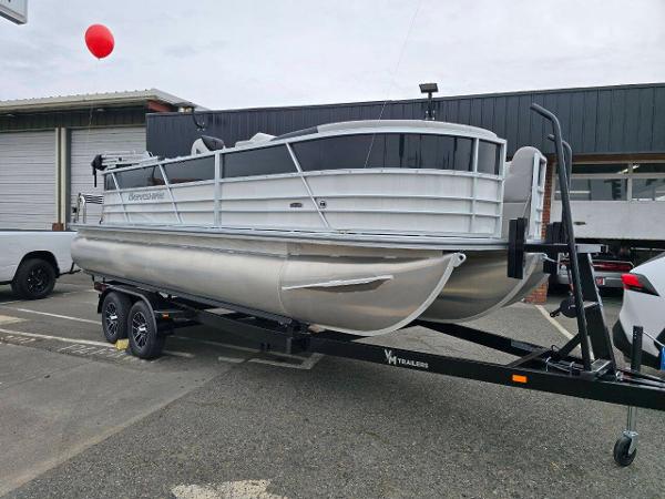Berkshire 22 RFX LE 2025 Berkshire 22 RFX LE pontoon boat on trailer, parked outdoors.