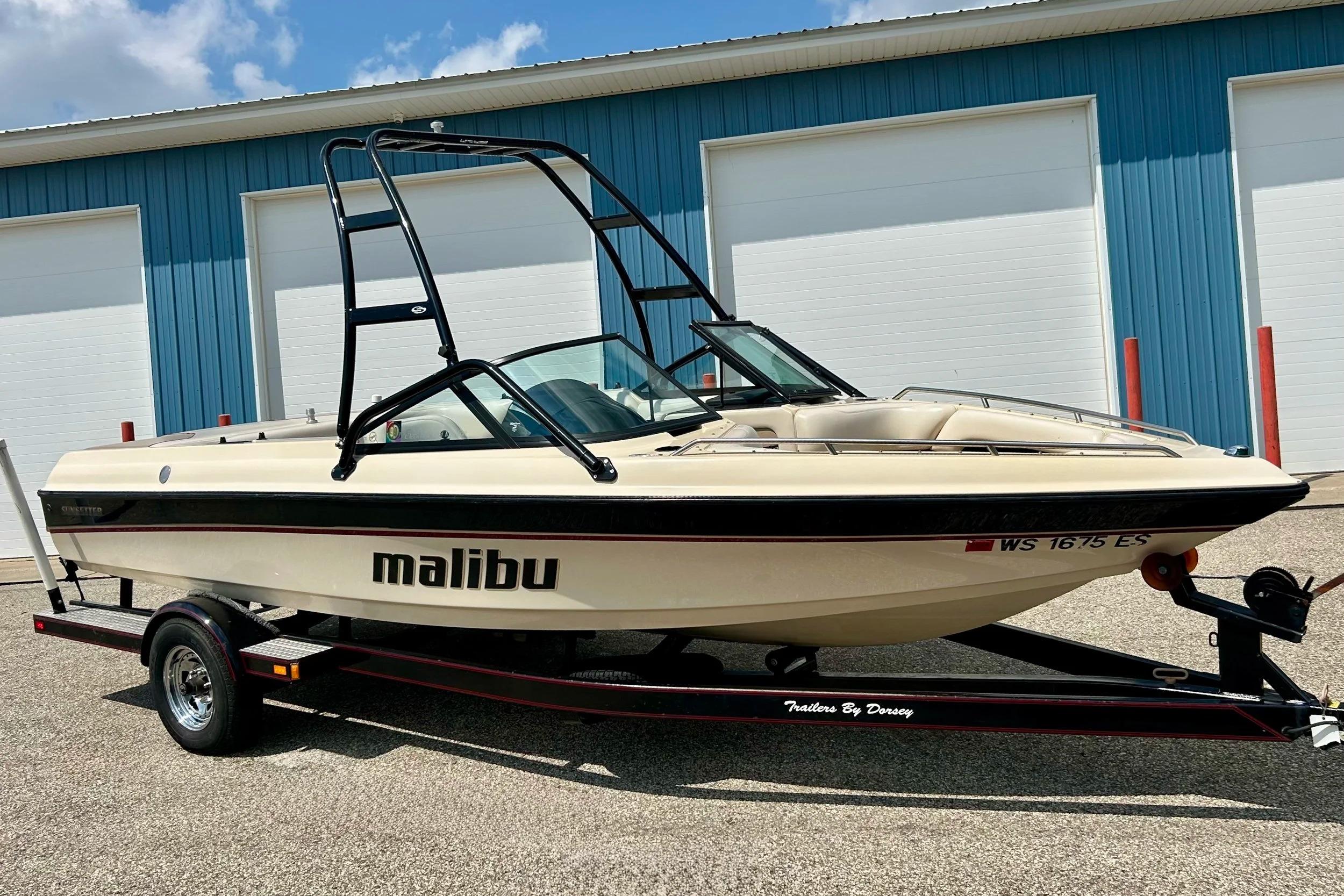 Malibu Sunsetter VLX 1999 Malibu Sunsetter VLX boat on trailer, parked near blue building.