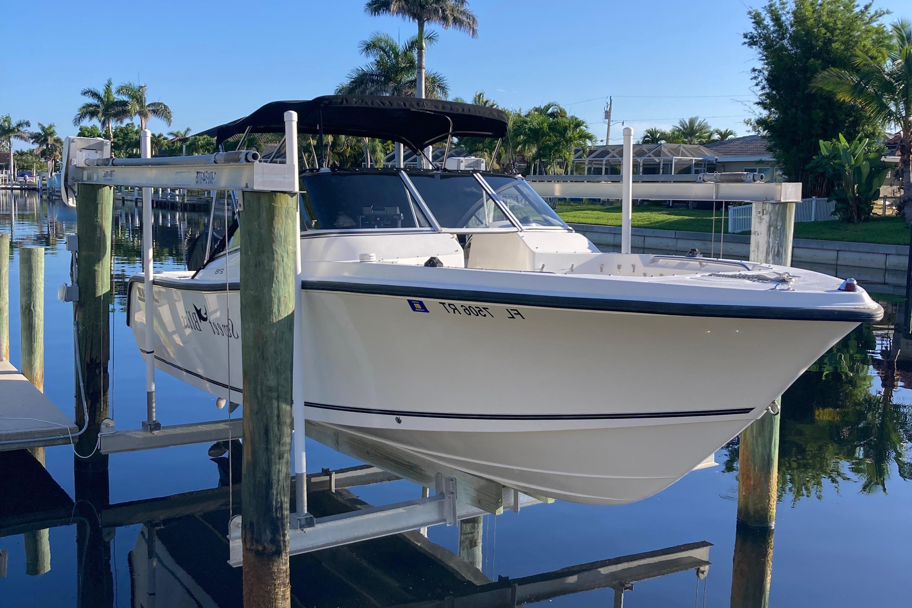 Mako 216 Dual Console 2006 Mako 216 Dual Console boat docked on a lift, surrounded by palm trees.