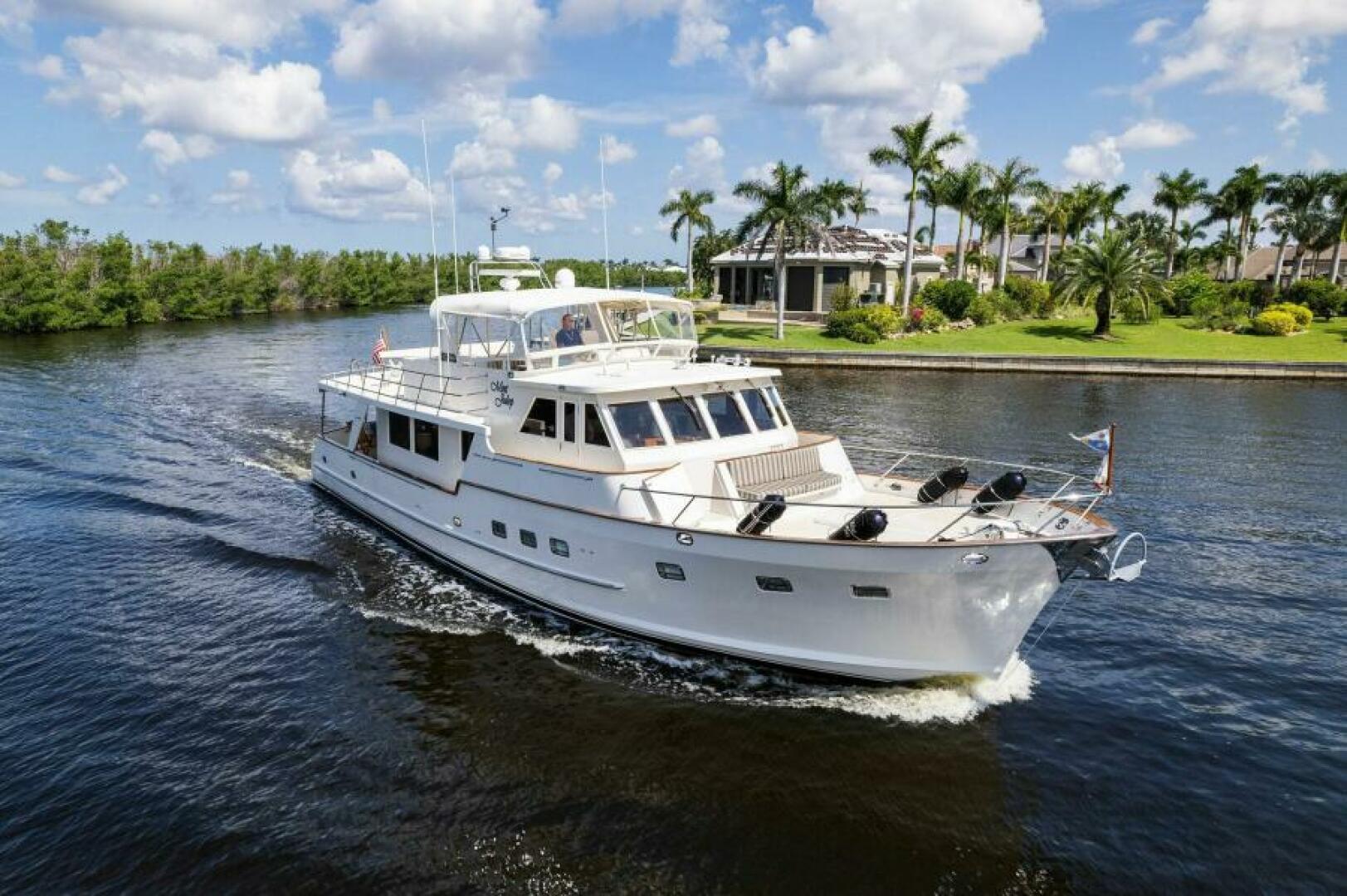 Grand Alaskan 64 pilot house 2001 Grand Alaskan 64 Pilot House yacht cruising on a scenic waterway with palm trees.
