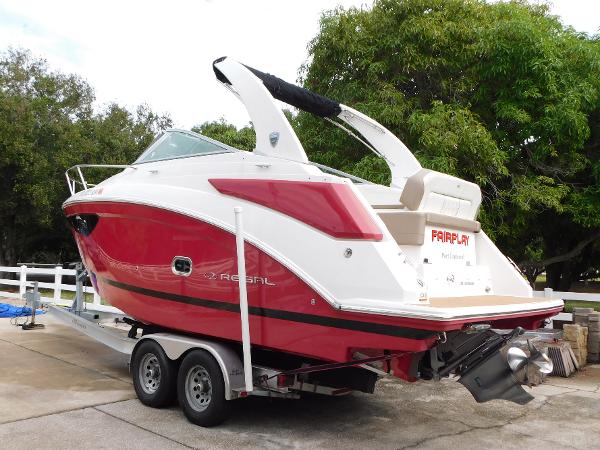 Regal 26 Express 2018 Regal 26 Express boat on trailer, red and white design, parked outdoors.