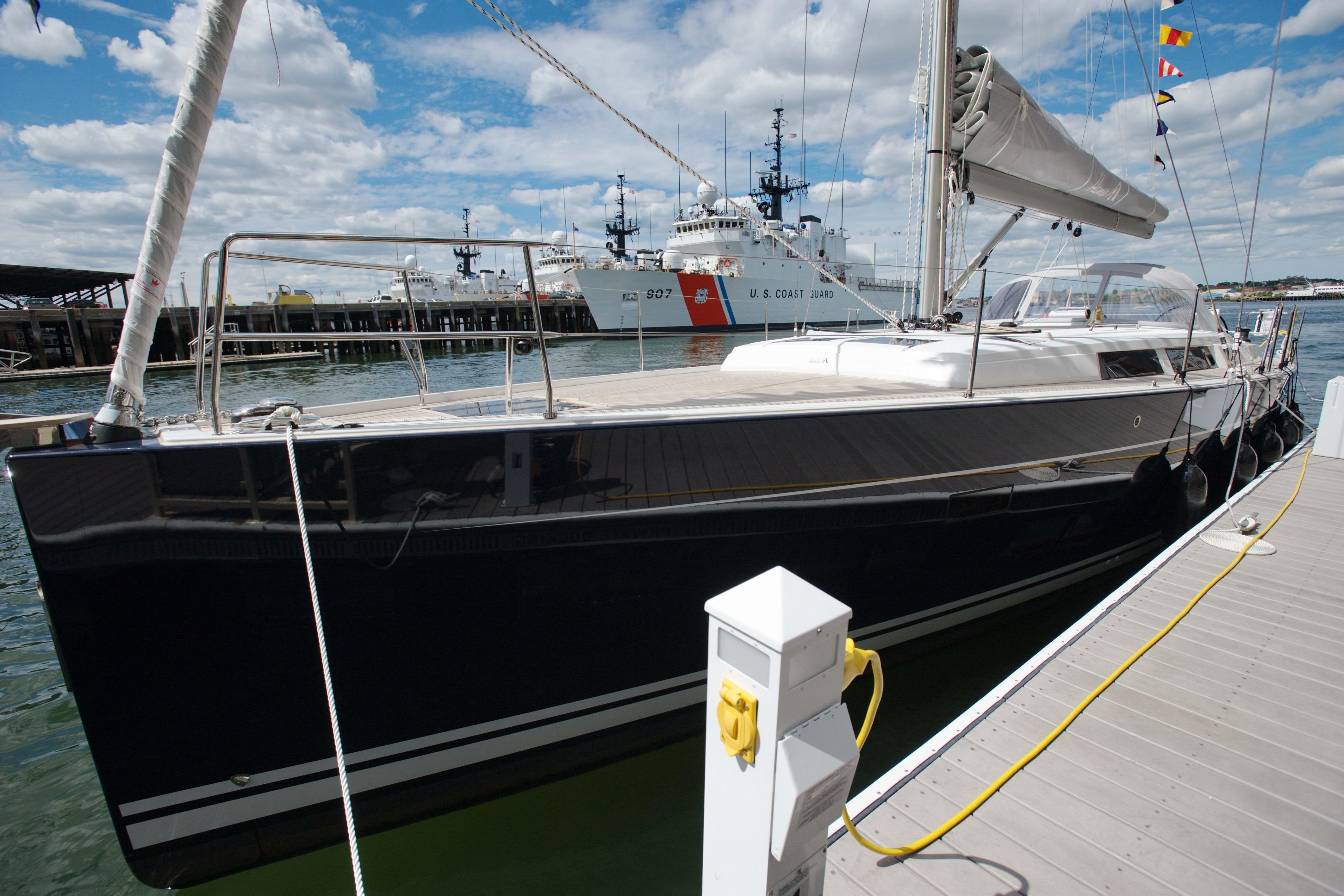Hanse 445 2014 Hanse Yachts 445 sailboat docked at marina with coast guard ship in background.