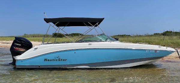 NauticStar 243 DC 2021 NauticStar 243 DC boat with Yamaha engine, anchored on a sandy beach.