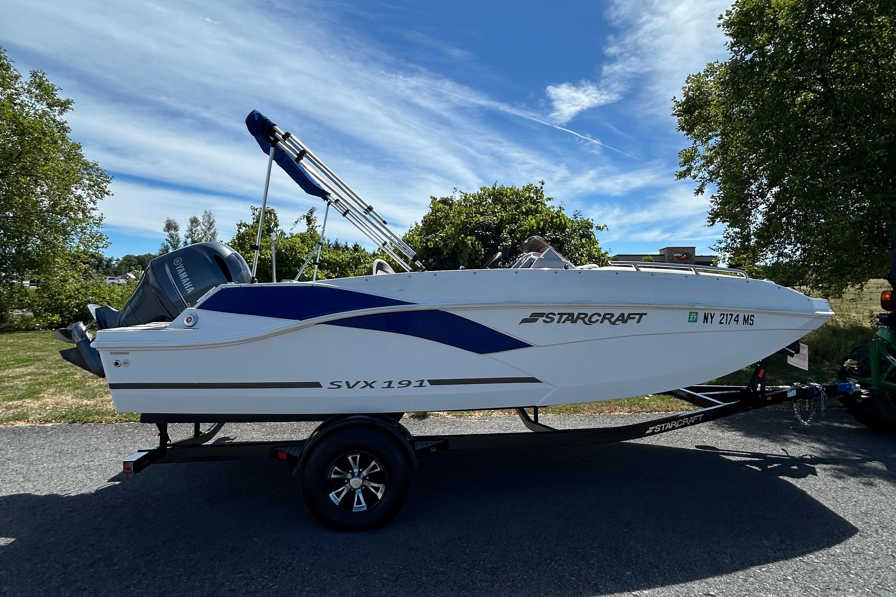 Starcraft SVX 191 OB 2021 Starcraft SVX 191 OB boat on trailer, parked outdoors under blue sky.