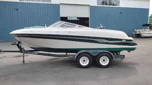 Four Winns 200 Horizon 1999 Four Winns 200 Horizon boat on a trailer outside a blue building.