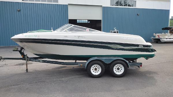 Four Winns 200 Horizon 1999 Four Winns 200 Horizon boat on a trailer outside a blue building.