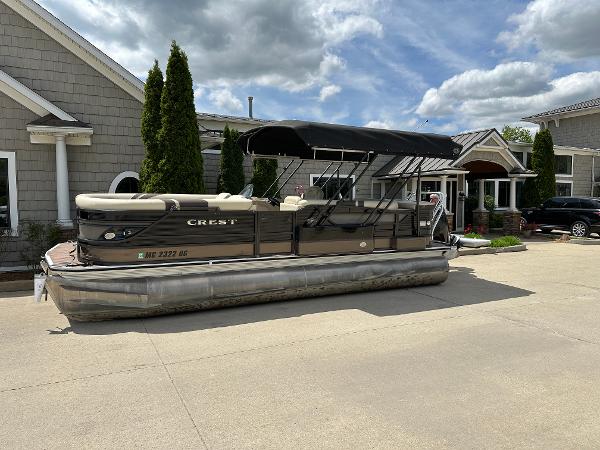 Crest Classic 230 L 2019 Crest Classic 230 L pontoon boat parked outside a building under a cloudy sky.