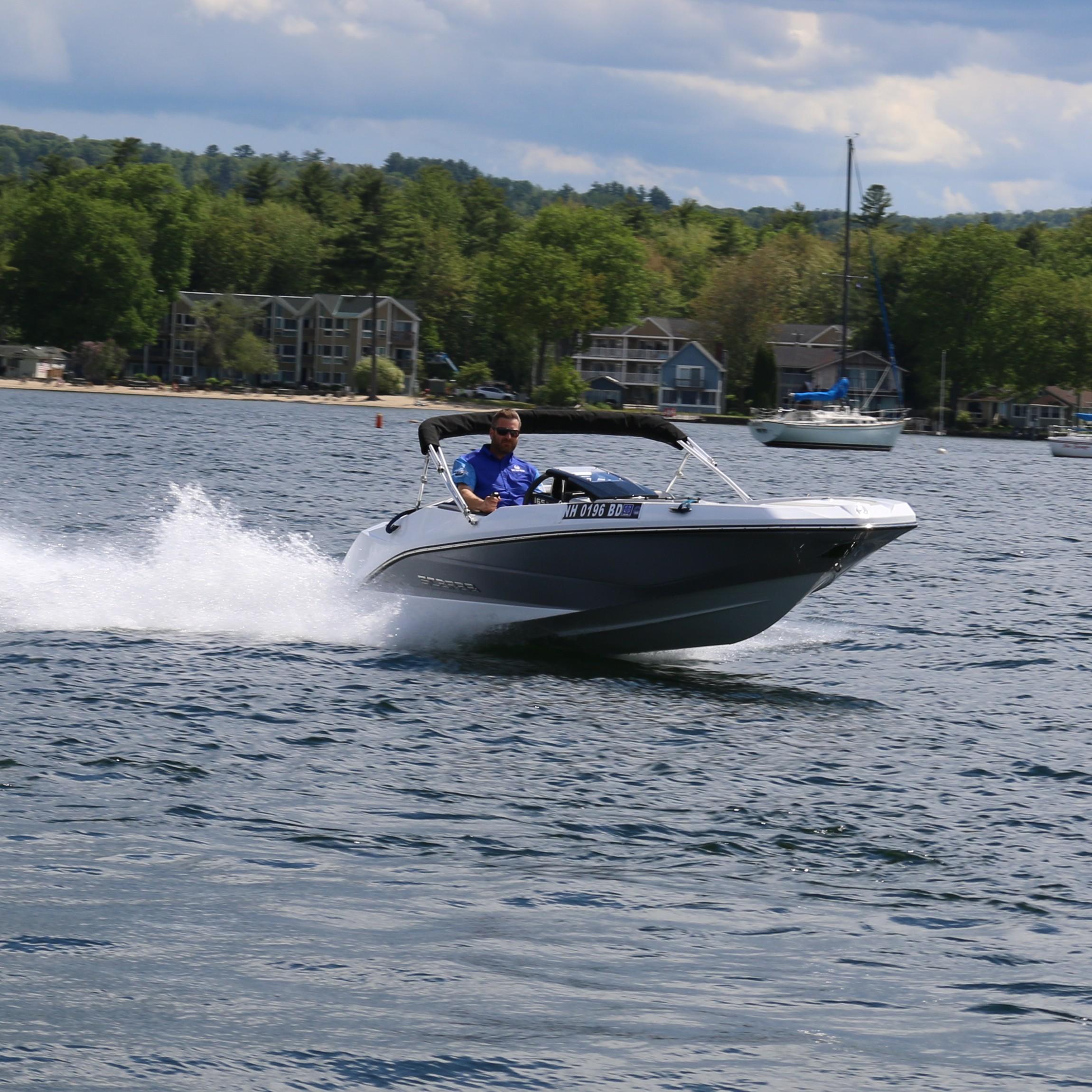 Scarab 165 SE 2025 Scarab 165 SE speedboat cruising on a lake with scenic background.