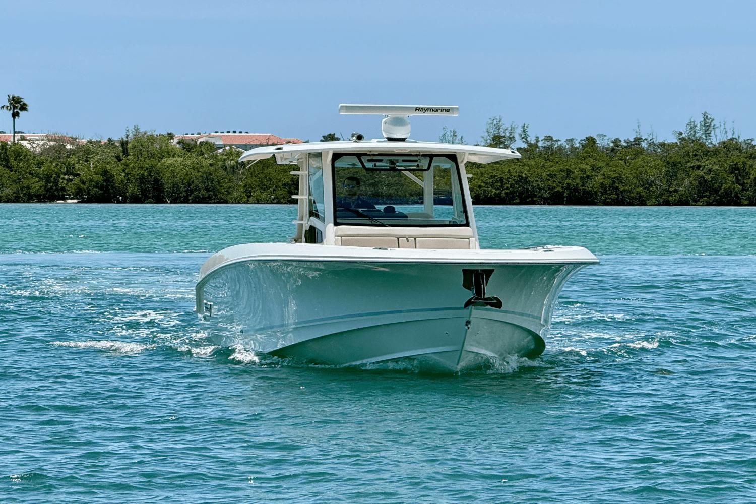 Boston Whaler 380 Outrage 2018 Boston Whaler 380 Outrage cruising on turquoise water, surrounded by lush greenery.