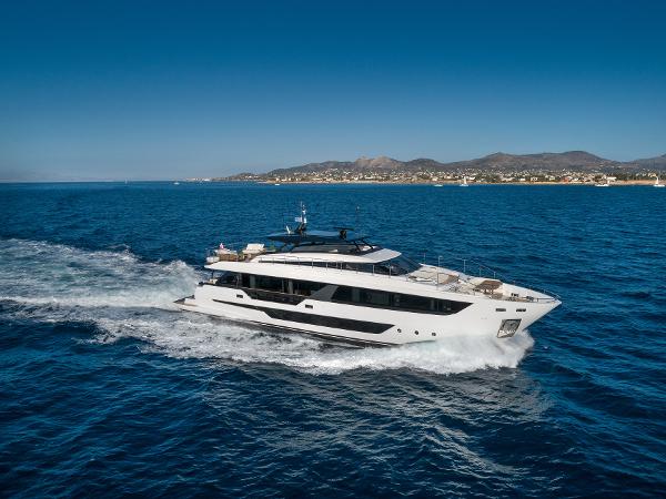 Ferretti Yachts 1000 2023 Ferretti Yachts 1000 cruising on open sea with scenic coastline backdrop.