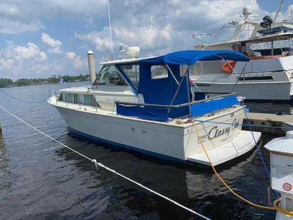 Chris-Craft 31 Commander 1968 Chris-Craft 31 Commander boat docked with blue canopy and calm waters.
