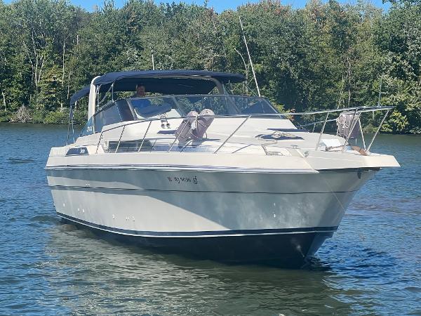 Silverton 34 Express 1988 Silverton 34X Express boat cruising on a calm lake with forested background.